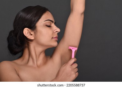 A Young Woman Using Razor To Remove Underarm Hair