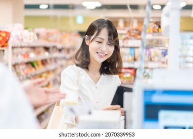 Young woman using self-checkout and e-money payment