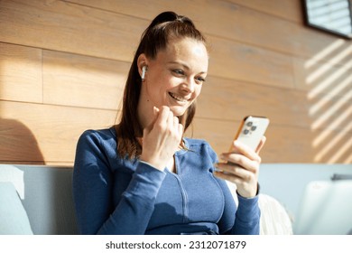 Young woman using a smart phone at home - Shutterstock ID 2312071879