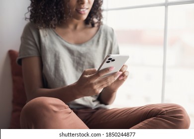 Young woman using smartphone at home. Student girl texting on mobile phone in her room. Communication, home work or study, connection, mobile apps, technology, lockdown, lifestyle concept
