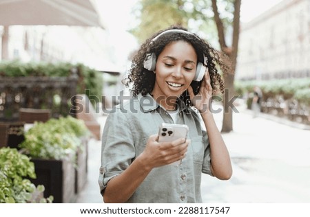 Young woman 
using smartphone and listening to the music