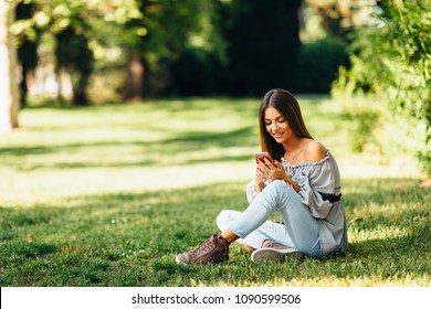 Young Woman Using A Smartphone In The Park