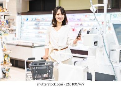 Young Woman Using Smartphone Payment At A Supermarket