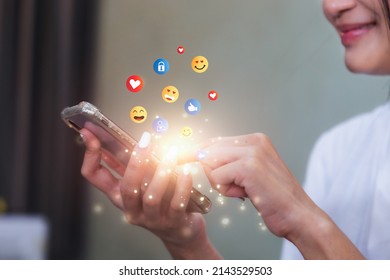 Young woman using smartphone sending emojis. Mobile smartphone sending text messages emoji emoticon. - Shutterstock ID 2143529503