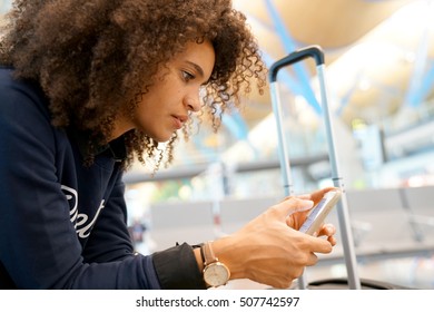 Young woman using smartphone while waiting at the airport                   - Shutterstock ID 507742597