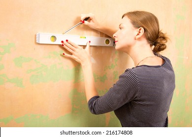 Young Woman Using A Spirit Level. 