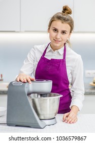 Young Woman Using Stand Mixer In Kitchen