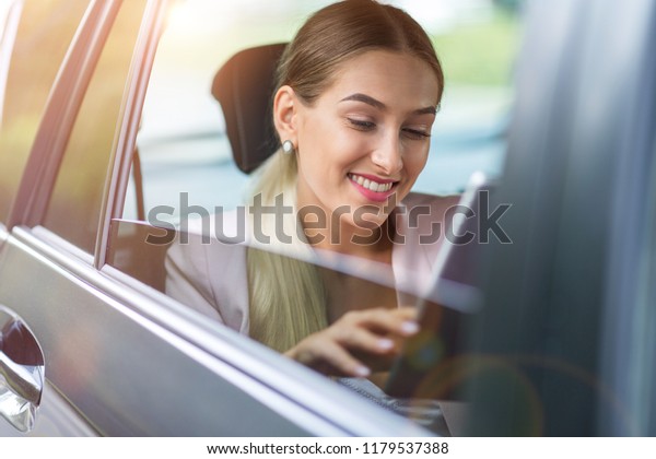 Young woman using a tablet\
in a car