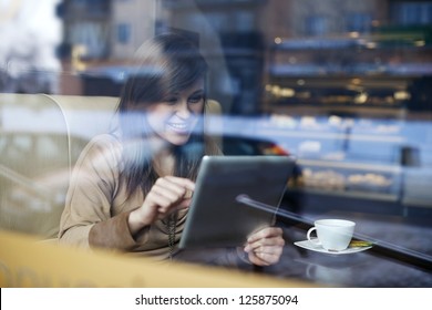 Young Woman Using Tablet In Coffee Shop