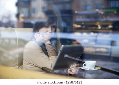 Young Woman Using Tablet In Coffee Shop