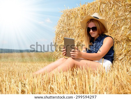 Young woman using tablet on field