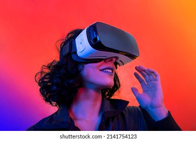 The young woman is using virtual reality viewer. Modern woman portrait with trendy look and bright colors.