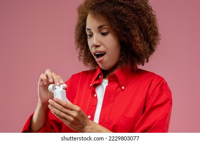 Young woman using wireless headphones and looking contented - Shutterstock ID 2229803077