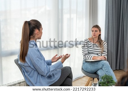 Young woman victim of domestic violence or robbery or mobbing at work talks to an expert psychotherapist for therapy in a comfortable apartment. Psychologist discuss mental problems trauma after shock