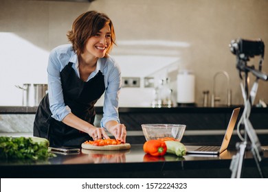 Young woman videoblogger cooking at the kitchen and filming - Powered by Shutterstock