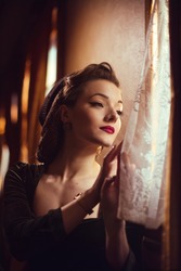 Young Woman In Vintage Clothes Looking Out The Window Inside A Retro Train