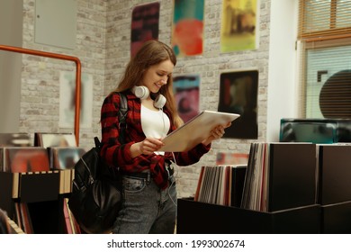 Young Woman With Vinyl Record In Store