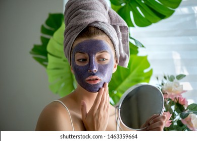 Young Woman With Violet Shiny Glamor Face Mask On Her Face In Her Home.  Spa And Wellness, Skin Care Concept. Selective Focus.