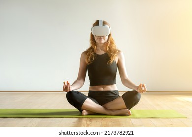 A Young Woman In Virtual Reality Glasses Makes Yoga Asana. Future Technology Concept.