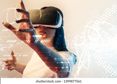 young woman in virtual reality headset gesturing with hands among glowing cyber illustration on beige background - Shutterstock ID 1399877561