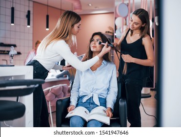 Young woman visit the beauty salon and get service from two female workers.