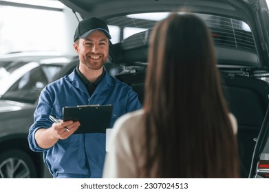 Young woman is visiting auto mechanic in garage. Repair service. - Powered by Shutterstock