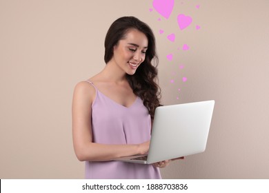 Young Woman Visiting Dating Site Via Laptop On Beige Background