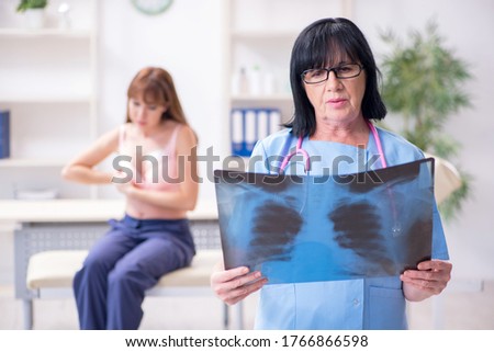 Young woman visiting old doctor oncologist in breast cancer