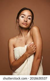 Young Woman With Vitiligo Problem Accepting Her Skin The Way It Is. Portrait Of Confident Young Woman In Bath Towel Against Brown Background.