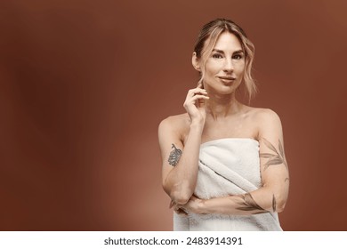 A young woman with vitiligo stands wrapped in a towel, showcasing her beauty and self-acceptance. - Powered by Shutterstock