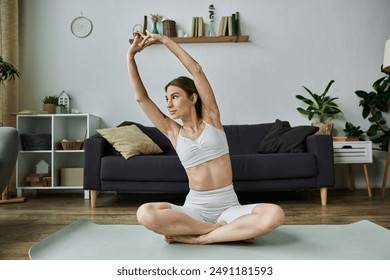 A young woman with vitiligo stretches her arms above her head while sitting in a cross-legged position on a yoga mat in a modern apartment. - Powered by Shutterstock