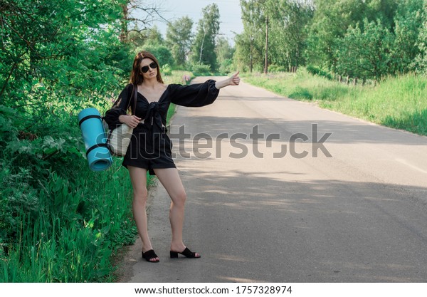 A young\
woman votes on the road. Summer\
travel.