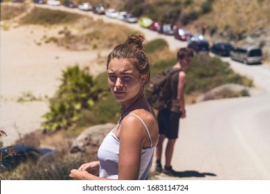 young woman walking along a street looks back