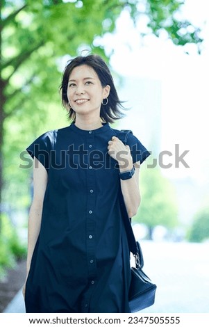 Young woman walking along a tree-lined street