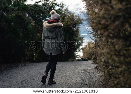 Young woman walking among trees in the forest. Winter season