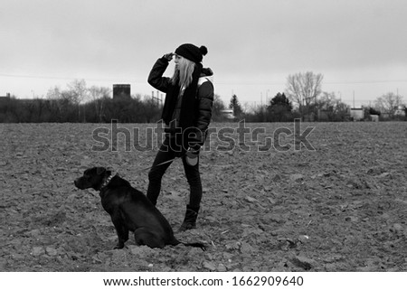 young woman walking the dog in the field
