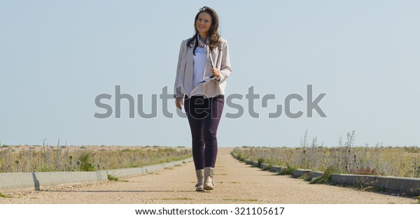 Young Woman Walking Down Long Road Stock Photo (Edit Now) 321105617