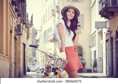 Young Woman Walking With Her Bicycle In The City