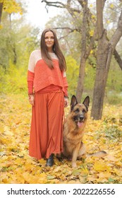 Young Woman Walking With Her German Shepherd Dog In Autumn Park Outdoor