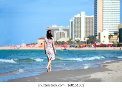 Young woman walking on the beach in Tel-Aviv