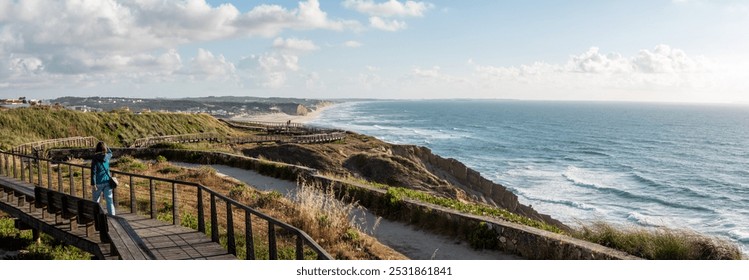 A young woman walking on a boardwalk at the Portuguese coast near village Foz do Aelho - Powered by Shutterstock