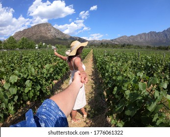 Young Woman Walking On A Grape Plantation To Make Wine In Franschhoek, A City In South Africa, Located In The Western Cape Province