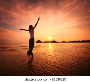 Young Woman Walking On A Sandy Beach