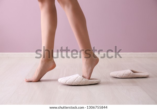 Young\
woman walking on tiptoe without slippers at\
home