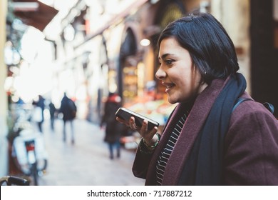 young woman walking outdoor talking smartphone leaving voicemail - conversation, communication, happiness concept