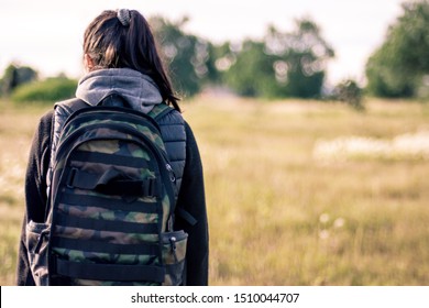 young woman walking outside in a field full of plants and carrying a backpack while enjoy the view  - Shutterstock ID 1510044707