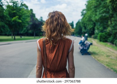 A Young Woman Is Walking In A Park