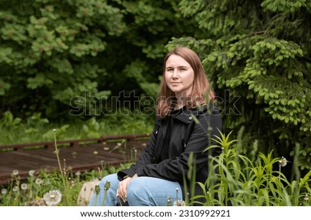 young woman walking in the park in the summer in rainy weather