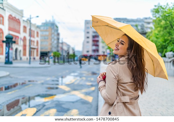 雨の日に傘を差して歩く若い女性 秋の町の女性 雨の日に黄色い傘で歩く女性 長毛のおしゃれな若い女の子が一緒に歩く時に微笑むポートレート の写真素材 今すぐ編集