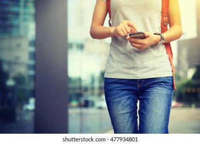 Young Woman Walking With Smart Phone In Modern City